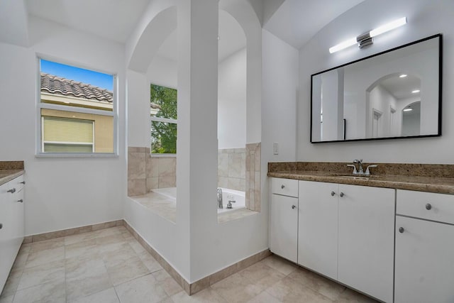 bathroom featuring a bathing tub, vanity, and tile flooring