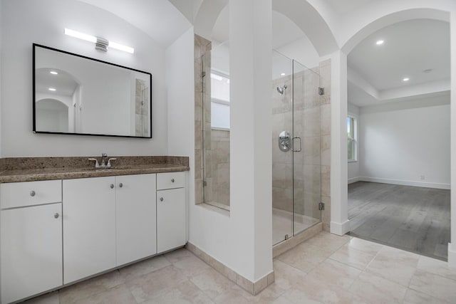 bathroom featuring vanity, a shower with shower door, and wood-type flooring