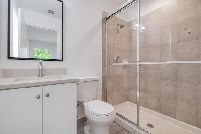 bathroom featuring an enclosed shower, tile floors, vanity with extensive cabinet space, and toilet