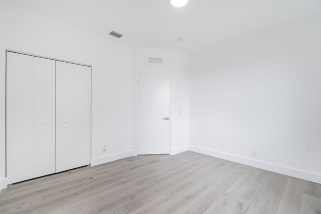 unfurnished bedroom featuring a closet and light hardwood / wood-style flooring