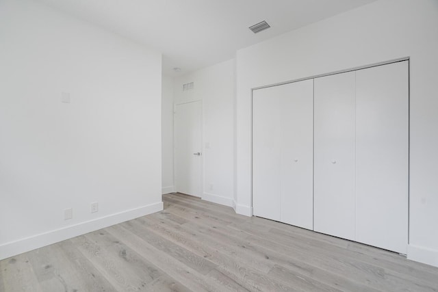 unfurnished bedroom featuring a closet and light hardwood / wood-style flooring