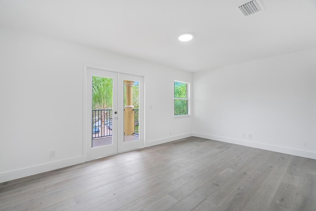 unfurnished room with light wood-type flooring and french doors