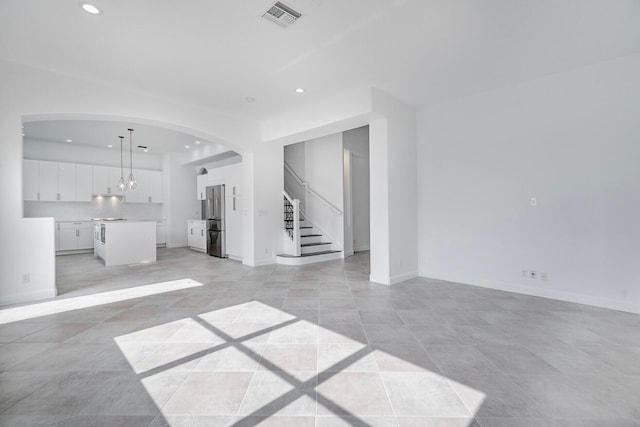 spare room with a chandelier and light tile floors