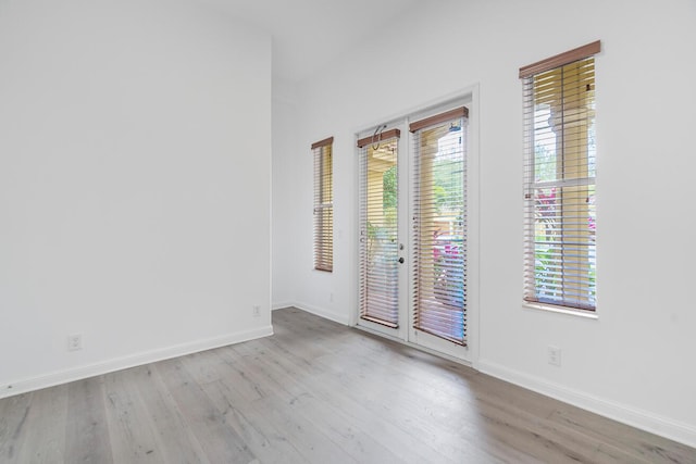 spare room with light hardwood / wood-style floors and french doors