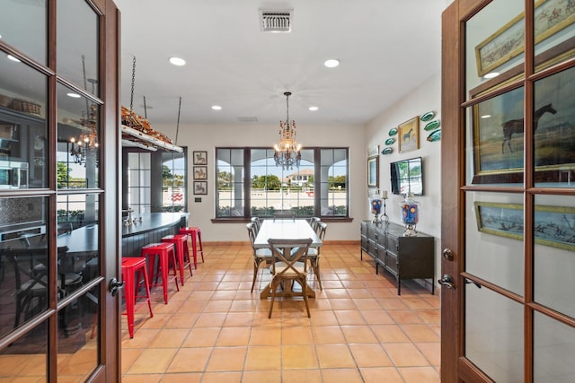 dining area featuring light tile floors and an inviting chandelier