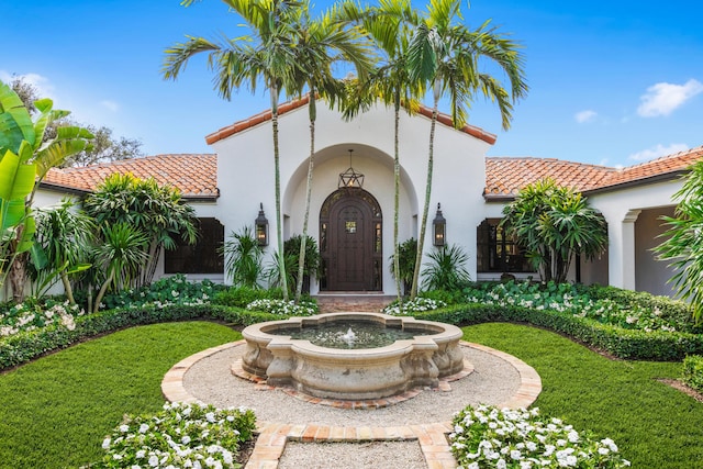 mediterranean / spanish-style house with a front yard