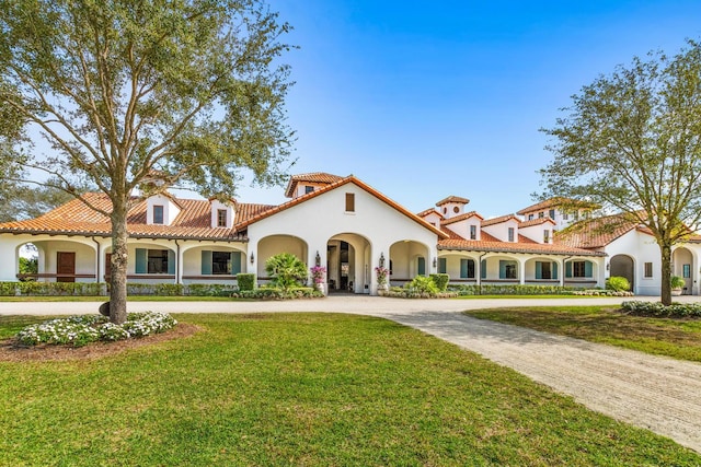 mediterranean / spanish home featuring a front lawn