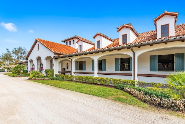 mediterranean / spanish home featuring a porch