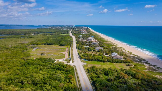 bird's eye view with a water view and a beach view