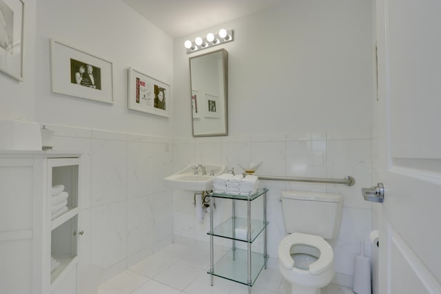 bathroom with tile walls, toilet, sink, backsplash, and tile flooring