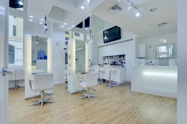 interior space featuring a towering ceiling, light hardwood / wood-style flooring, and rail lighting