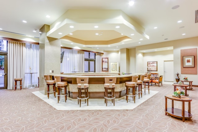 interior space featuring a kitchen breakfast bar, a spacious island, and a tray ceiling