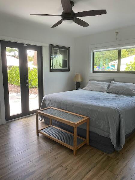 bedroom with french doors, access to exterior, ceiling fan, and hardwood / wood-style flooring