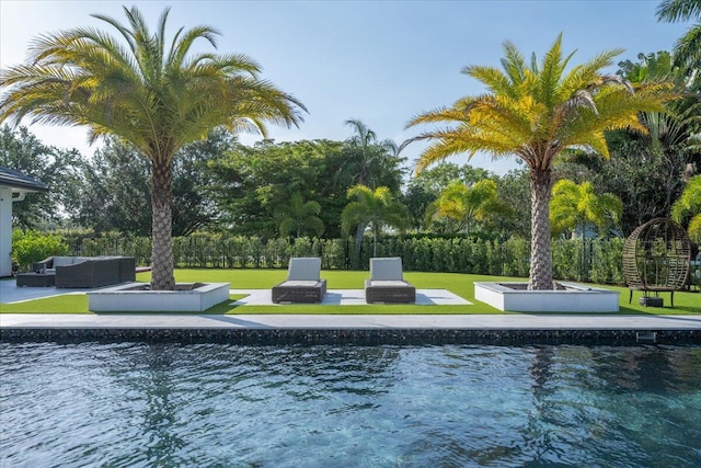 view of swimming pool featuring a yard, an outdoor living space with a fire pit, and a patio