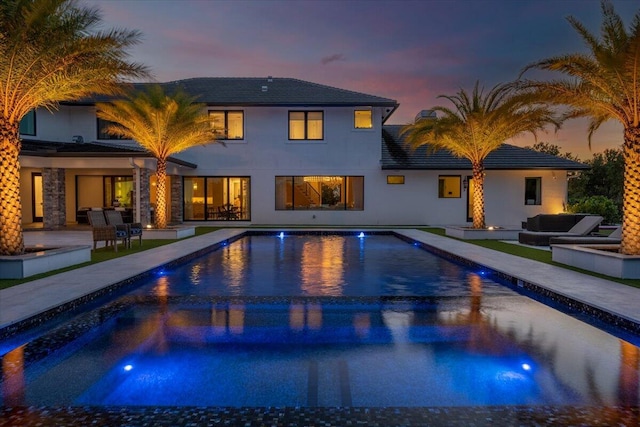 pool at dusk featuring a patio area