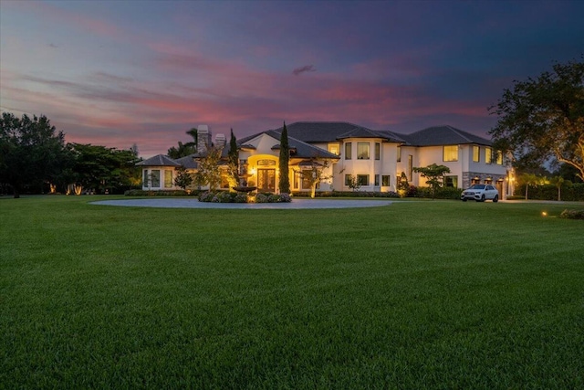 back house at dusk with a yard