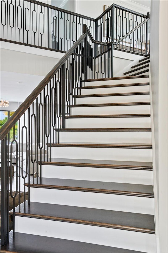 stairs featuring a chandelier