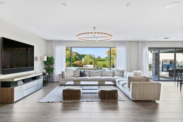 living room featuring a notable chandelier and light wood-type flooring