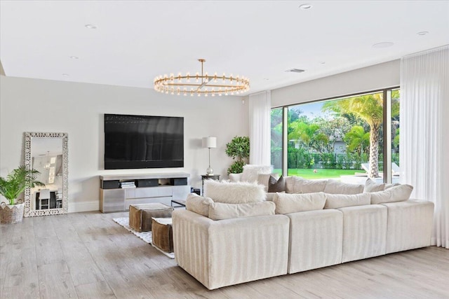 living room featuring light hardwood / wood-style flooring and an inviting chandelier