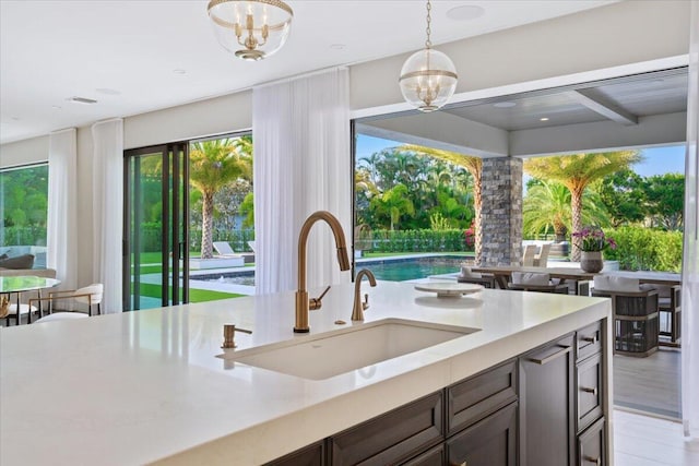 kitchen with an inviting chandelier, hanging light fixtures, sink, and a wealth of natural light