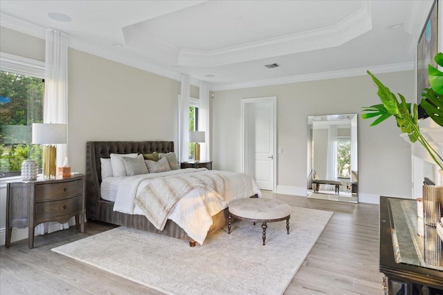 bedroom with a tray ceiling, wood-type flooring, and crown molding