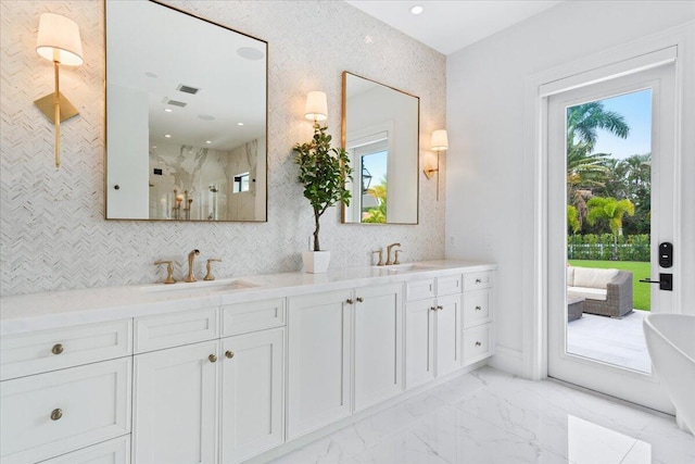 bathroom featuring double sink vanity, tile flooring, a bathing tub, and a wealth of natural light