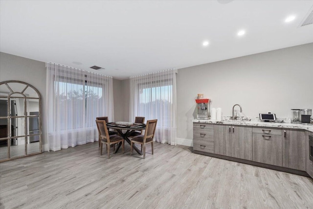 dining room with light hardwood / wood-style floors and sink