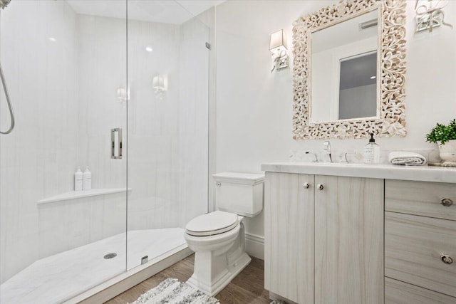 bathroom with an enclosed shower, vanity, hardwood / wood-style flooring, and toilet