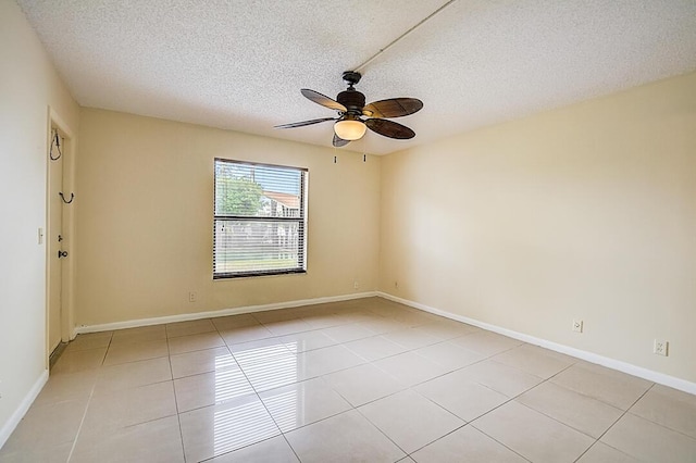 empty room with light tile floors, a textured ceiling, and ceiling fan