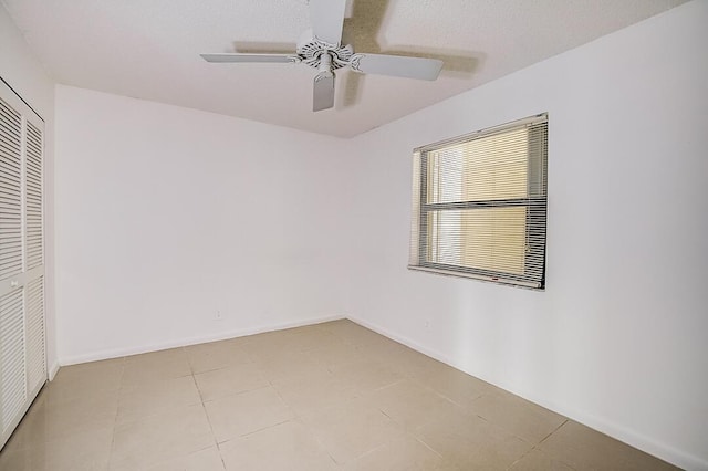 tiled empty room with ceiling fan