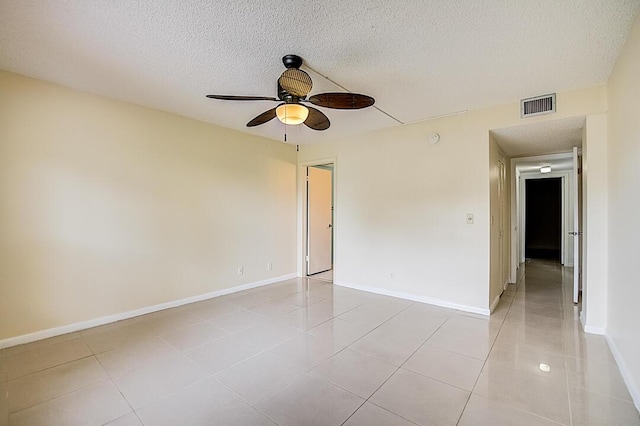 unfurnished room featuring light tile floors, a textured ceiling, and ceiling fan