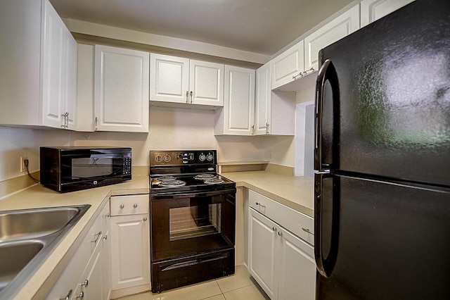 kitchen with sink, light tile floors, black appliances, and white cabinetry