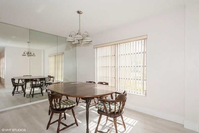 dining area featuring light wood-type flooring and an inviting chandelier