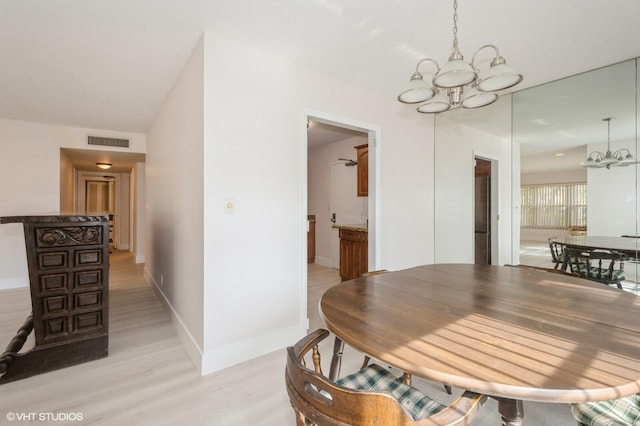 dining room featuring a notable chandelier and light wood-type flooring