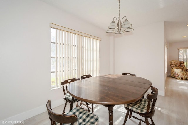 dining space with a notable chandelier and light hardwood / wood-style flooring