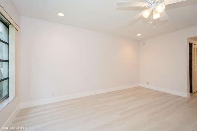 empty room with a wealth of natural light, light hardwood / wood-style floors, and ceiling fan