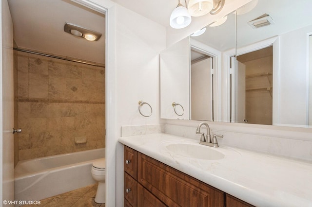 full bathroom featuring tiled shower / bath, tile patterned floors, toilet, and vanity