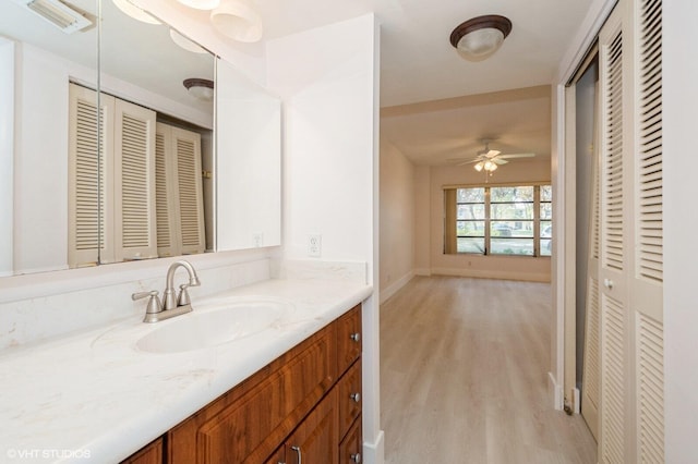 bathroom with vanity, hardwood / wood-style floors, and ceiling fan