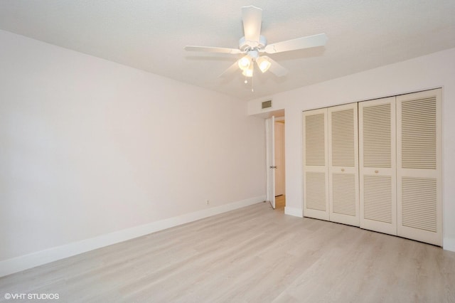 unfurnished bedroom featuring ceiling fan, a closet, and light hardwood / wood-style flooring