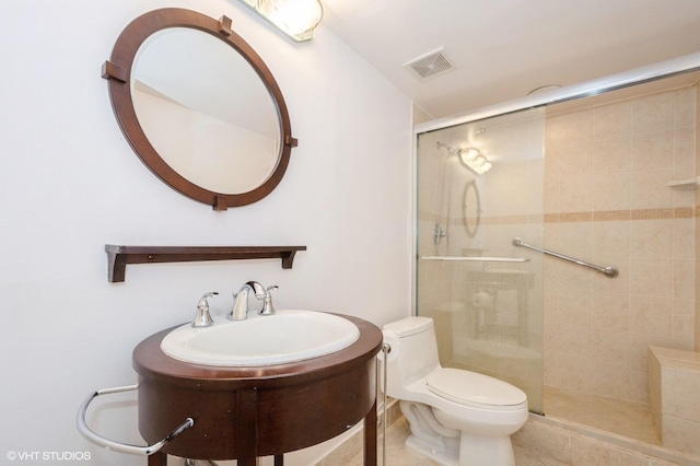 bathroom featuring vanity, toilet, and a shower with door