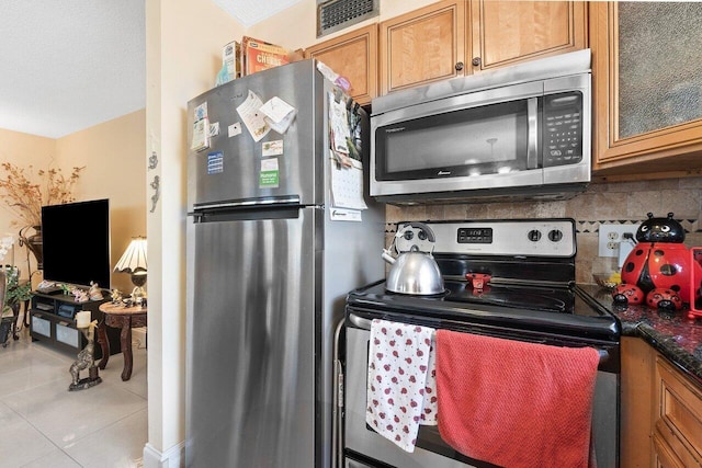 kitchen with tasteful backsplash, appliances with stainless steel finishes, and light tile floors