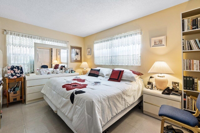 tiled bedroom with multiple windows and a textured ceiling