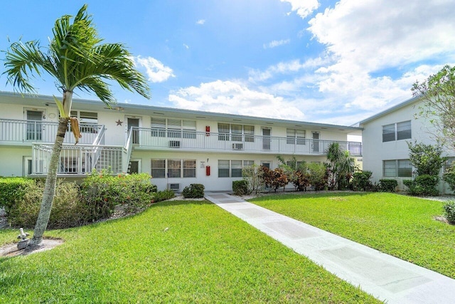 view of front of house with a balcony and a front lawn