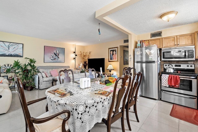 tiled dining area with a textured ceiling