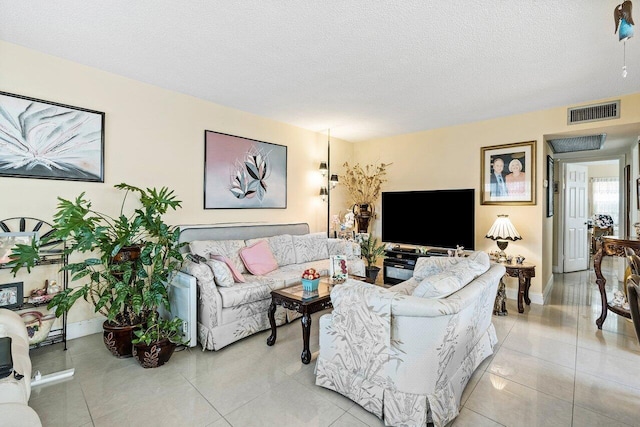 living room featuring a textured ceiling and light tile flooring