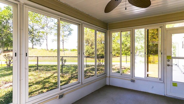 unfurnished sunroom featuring plenty of natural light, ceiling fan, and wood ceiling