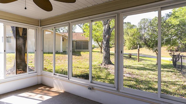 unfurnished sunroom featuring ceiling fan