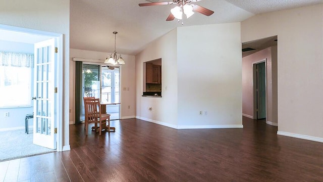 interior space with lofted ceiling, dark wood-type flooring, a textured ceiling, and ceiling fan with notable chandelier