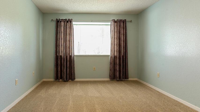 carpeted empty room featuring a textured ceiling