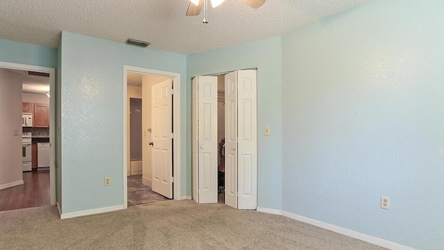 unfurnished bedroom featuring a textured ceiling and dark colored carpet